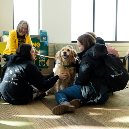 three female students petting a dog