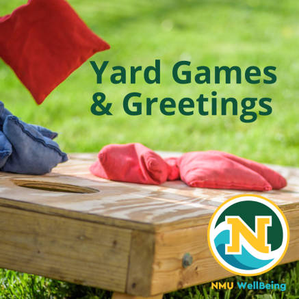 A wooden cornhole board with three blue cornhole bags and three red cornhole bags on top, in a grassy area. The title states "Yard Games and Greetings" and includes the NMU WellBeing stamp in the lower right corner.
